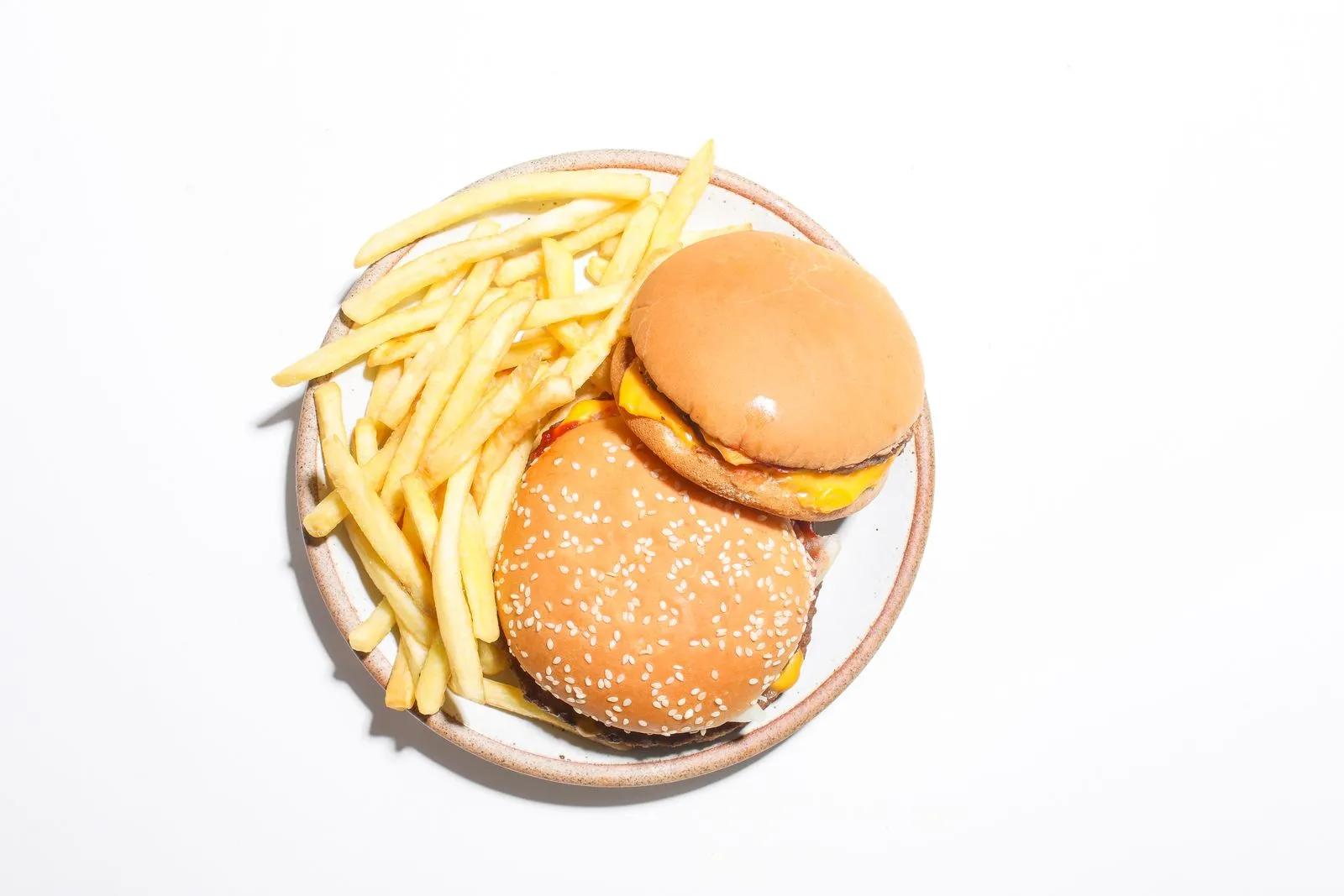 Fast food burgers and french fries served on a plate, illustrative photo